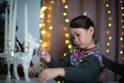 Cute girl with christmas decoration sitting at home
