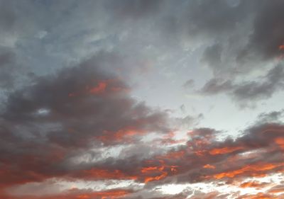 Low angle view of storm clouds in sky during sunset