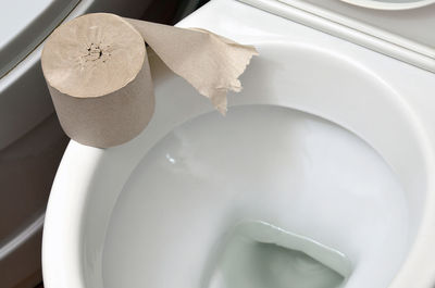 High angle view of tissue roll on white toilet bowl