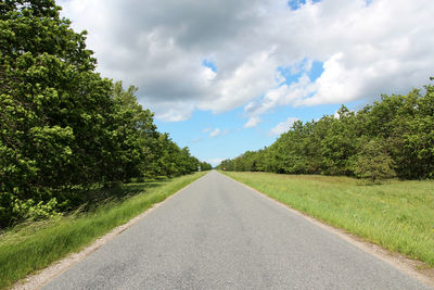 Road amidst trees against sky
