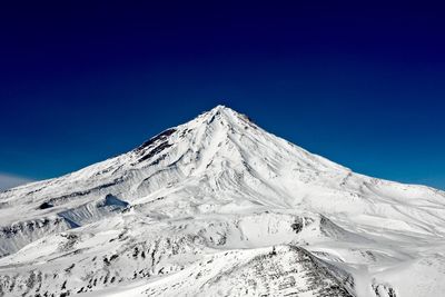 Scenic view of snowcapped mountains against blue sky