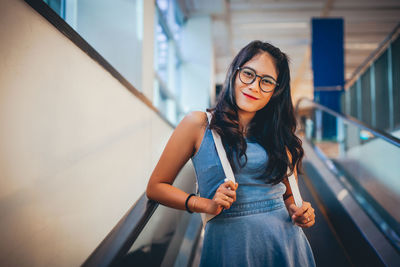 Portrait of cute woman standing on escalator