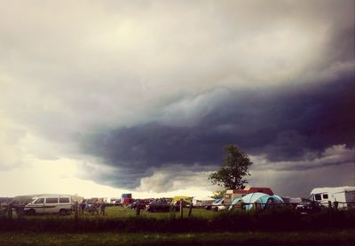 View of field against cloudy sky
