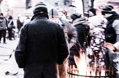 Rear view of people walking on street in city