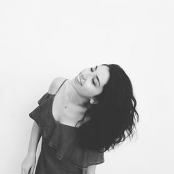 Portrait of smiling young woman against white background
