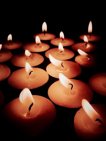 Close-up of illuminated candles in darkroom | ID: 100287514