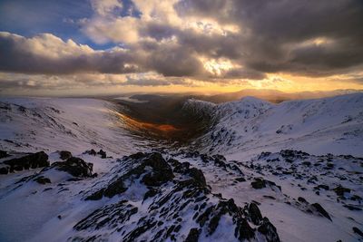 Scenic view of mountains against cloudy sky