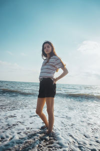 Full length of young woman standing on beach