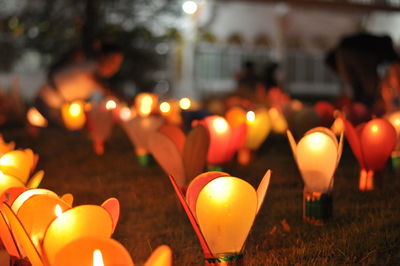 Close-up of lit candles on fire at night