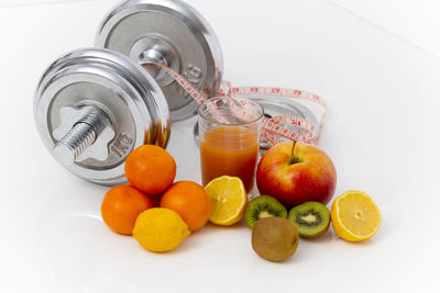 High angle view of oranges in glass jar on white background