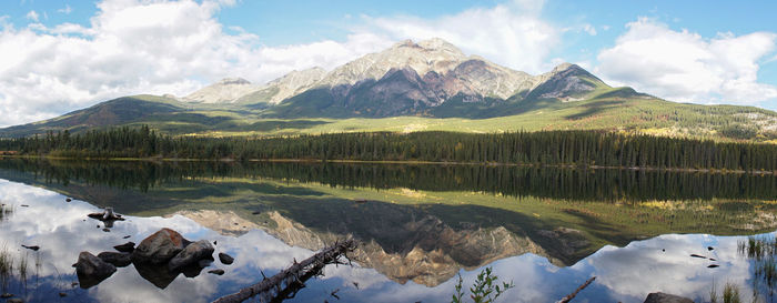 Scenic view of lake by snowcapped mountains against sky