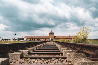 Railroad tracks against cloudy sky