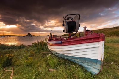 Ship moored on sea shore against sky