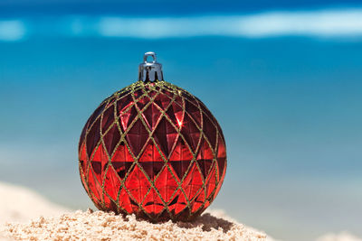 Close-up of christmas ornament on sand at beach