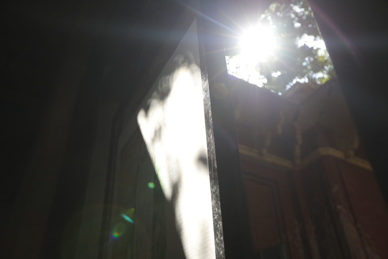 LOW ANGLE VIEW OF SUNLIGHT STREAMING THROUGH WINDOW ON BUILDING