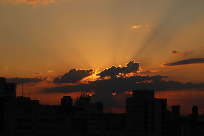 Silhouette buildings against sky during sunset