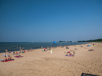 People on beach against clear sky
