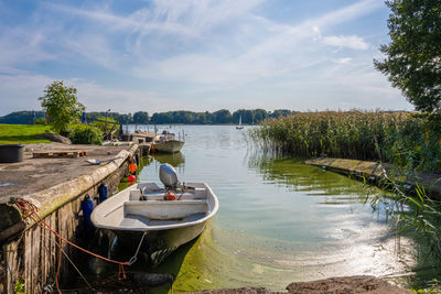 Boats moored in lake against sky