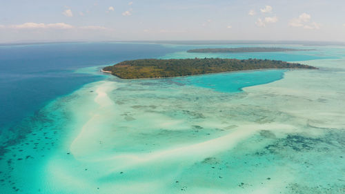 Sandy beach on a tropical island by coral reef atoll from above. mansalangan sandbar