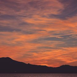 Scenic view of silhouette mountains against romantic sky at sunset