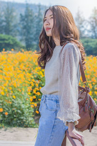 Young woman standing against white wall