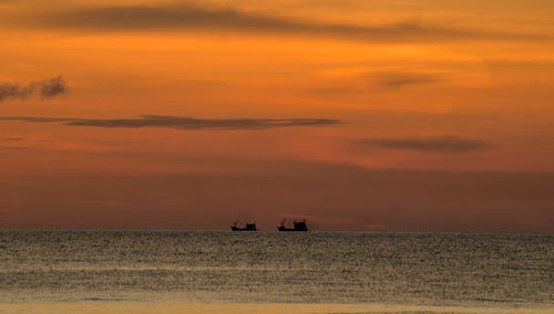 Scenic view of sea against orange sky