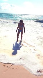 Full length of child on beach against sky