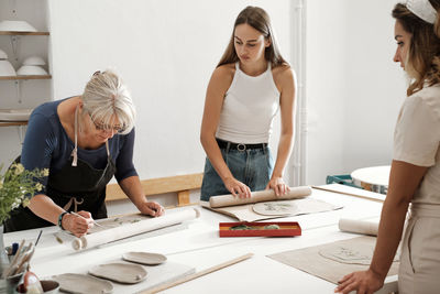 Pottery workshop in studio. people working with clay on the table. adults learning to do ceramic