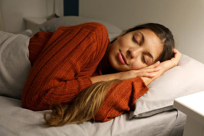 Young woman sleeping on bed at home