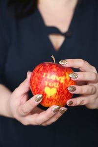 Midsection of woman holding apple with i love you text 