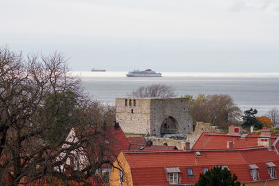 Scenic view of sea by buildings against sky