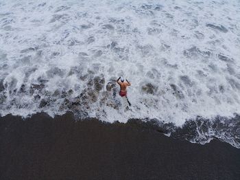 High angle view of shirtless man in sea
