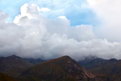 Scenic view of mountains against cloudy sky