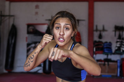 Portrait of woman in fighting stance at gym