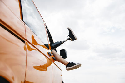 Legs of prosthetic young man dangling out of camper van window