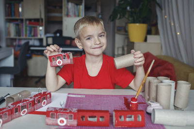 Portrait of boy playing with toy blocks while sitting at home