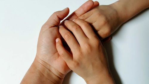 Close-up of hands over white background