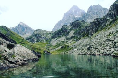 Scenic view of lake by mountains against clear sky