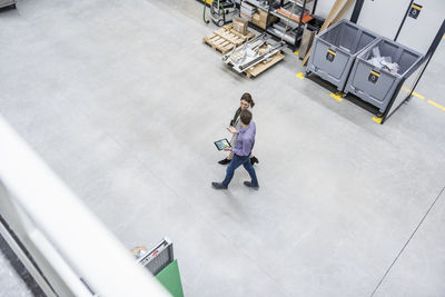 Businessman and woman walking in company, discussing new strategies