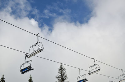 Low angle view of overhead cable car against sky