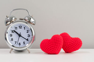 Close-up of clock on table against white background