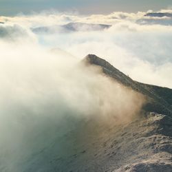 Scenic view of rocky mountains during foggy weather