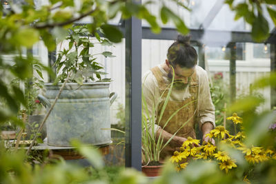 Rear view of man standing against plants