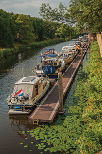 Boats anchored in pier on river at s-hertogenbosch. city with huge cultural life in netherlands.