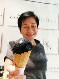 Portrait of smiling woman holding ice cream 