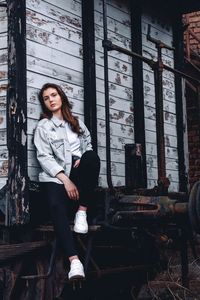 Portrait of young woman sitting in abandoned train cart