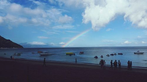 Panoramic view of people on beach against sky