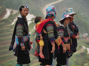 People in traditional clothing walking on field