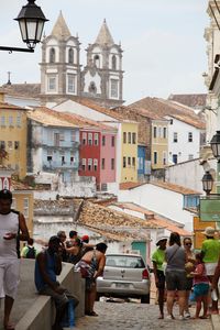 People on street amidst buildings in city