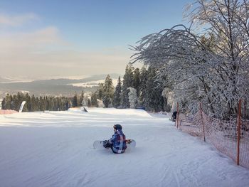 Man on snow covered mountain against sky